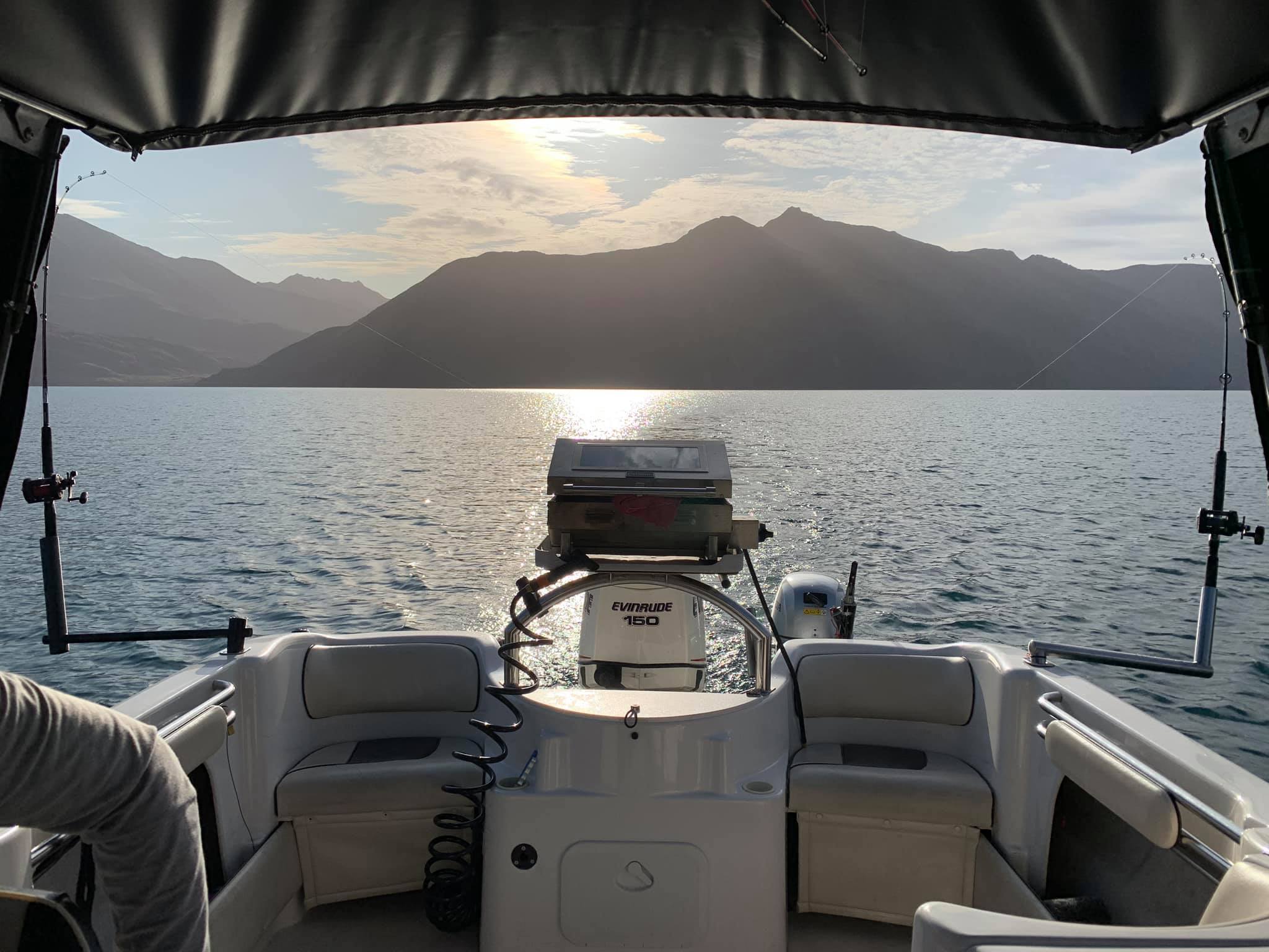 View from inside the boat looking out at a golden sunset over Lake Wanaka